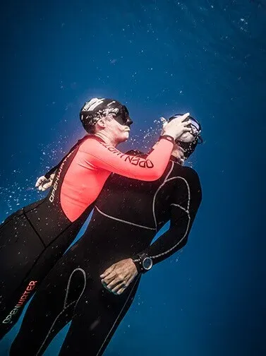 Scuba diver practising a rescue technique underwater during a diver training exercise.